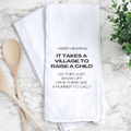 Humorous Kitchen Towel – "Village To Raise A Child"